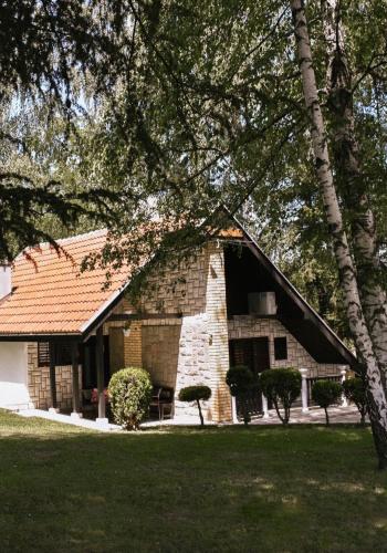a large brick building with a tree in front of it at Vikendice Stara Pruga in Gornji Milanovac