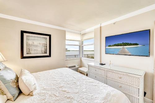 a white bedroom with a bed and a window at Cozy on Lover's Key in Fort Myers Beach