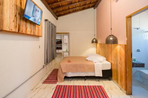 ein Schlafzimmer mit einem Bett und ein Badezimmer mit einer Badewanne in der Unterkunft Pousada Pitauá in Socorro