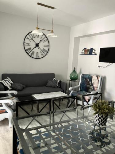 a living room with a couch and a clock on the wall at CASA AYARAN in Baeza