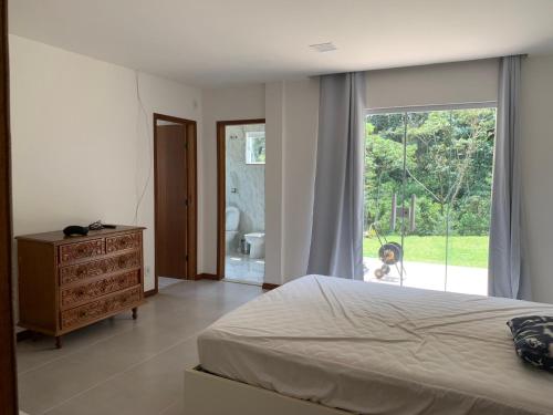 a bedroom with a bed and a large window at Hotel Fazenda Selva do Mato Limpo in São José do Rio Preto