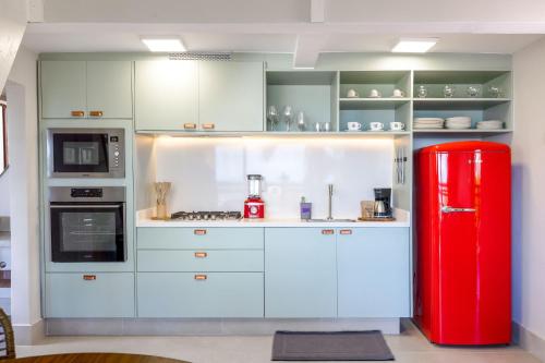 a kitchen with a red refrigerator in a room at Øko Villa in Juquei