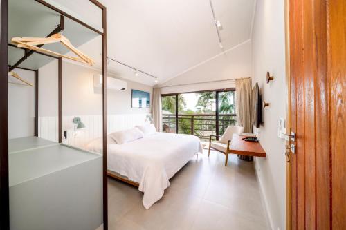 a bedroom with a bed and a mirror at Øko Villa in Juquei