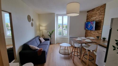 a living room with a blue couch and a table at Cristal 2 in Issoire