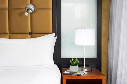 1 dormitorio con 1 cama y 1 mesa con lámpara en Millennium Hotel Broadway Times Square en Nueva York