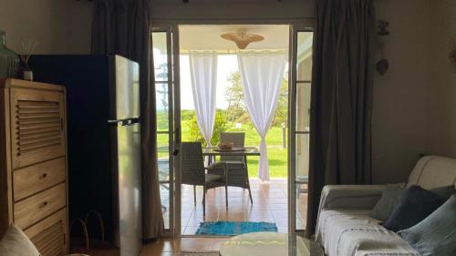 ein Wohnzimmer mit einer Tür, die auf eine Terrasse führt in der Unterkunft Celadon guadeloupe in Sainte-Anne