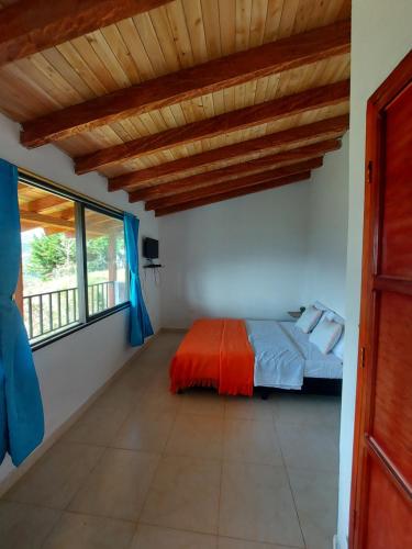 een slaapkamer met een bed en een groot raam bij Donde Andres Campestre - Guatape in El Peñol