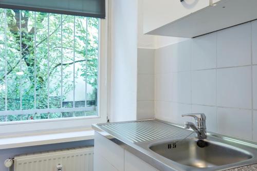 een keuken met een wastafel en een raam bij TOP SPOT MITTE . THE PLACE TO BE ! in Berlijn