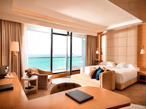 فندق Bilgah Beach في باكو: غرفة فندق مع غرفة نوم مع سرير وطاولة