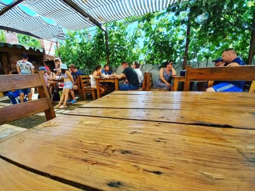 a large wooden table with a group of people sitting around it at Apartments Kraja in Velipojë