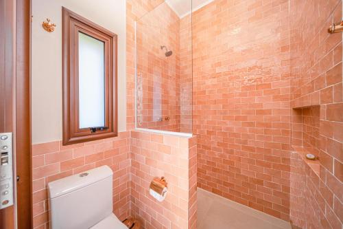 a bathroom with a toilet and a glass shower at Øko Villa in Juquei
