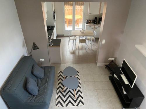 uma sala de estar com um sofá, uma mesa e uma cozinha em Maisonnette proche plage Saint-Malo em Saint Malo