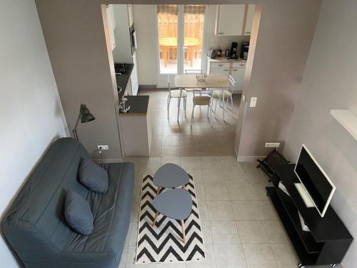 a living room with a couch and a table and a kitchen at Maisonnette proche plage Saint-Malo in Saint Malo