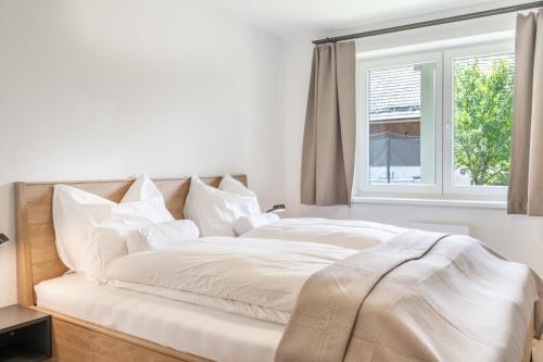 a white bed with white sheets and a window at Apartment Eden Wengerkopf in Tamsweg