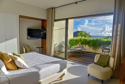 a bedroom with a bed and a view of the ocean at Le Martin Boutique Hôtel in Saint Martin