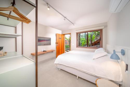 a bedroom with a bed and a window at Øko Villa in Juquei