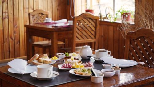 a wooden table with plates of food on it at Hotel Posada del Río - Chile Chico in Chile Chico