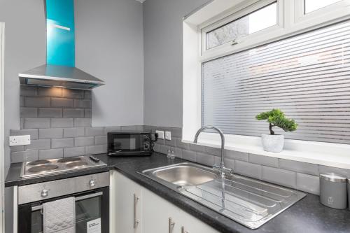una cocina con fregadero y ventana en Central thornaby rooms, en Thornaby on Tees