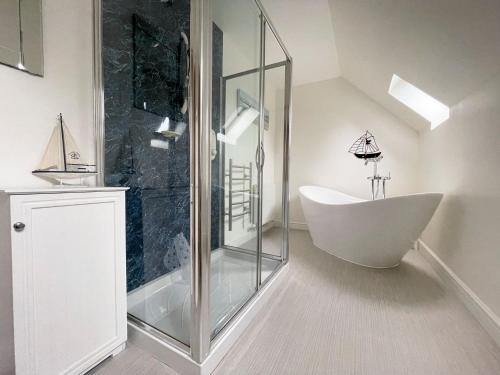 a bathroom with a tub and a glass shower at Rhianchaitel House in Bettyhill