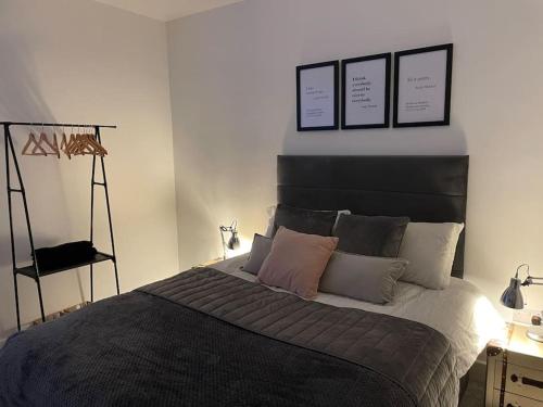 a bedroom with a bed with three pictures on the wall at Hill Garth Cottage - Luxury 2 Bed with Wood Burning Hot Tub in Wooler