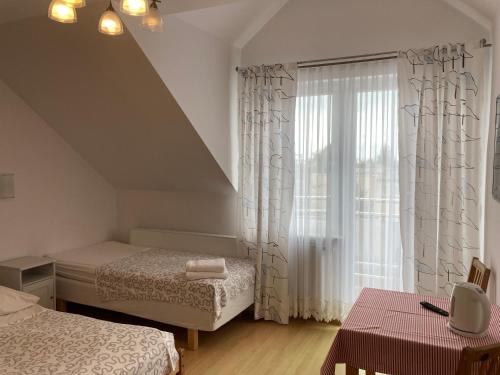Habitación pequeña con 2 camas y ventana en Glada en Jastarnia