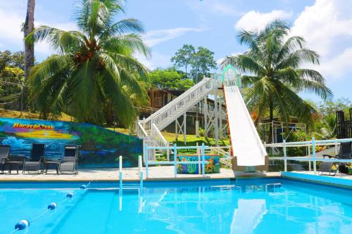 a swimming pool with a slide at a resort at Castillo Inspiracion Hostel in Bocas del Toro