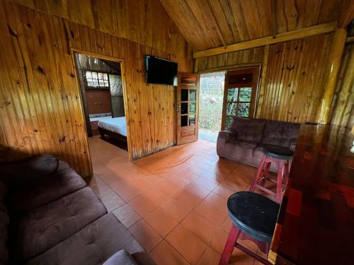 a living room with a couch and a tv at CABAÑA EL CEDRO in San Vito