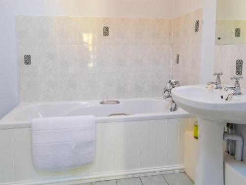 a bathroom with a sink and a bath tub and a sink at Cranberry Cottage in South Creake