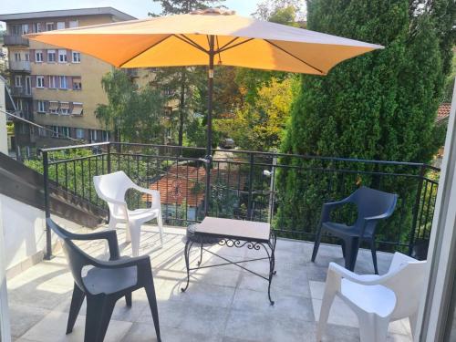 une terrasse avec une table, des chaises et un parasol dans l'établissement Open Space Apartment, à Belgrade