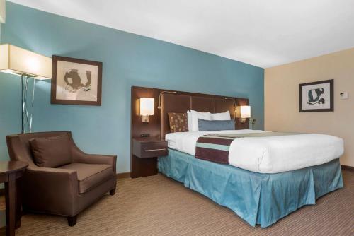 Una habitación de hotel con una cama grande y una silla. en Best Western Plus Tallahassee North Hotel, en Tallahassee