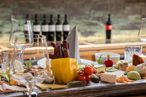 a table with wine glasses and a plate of food at KUHOTEL by Rilano in Waidring