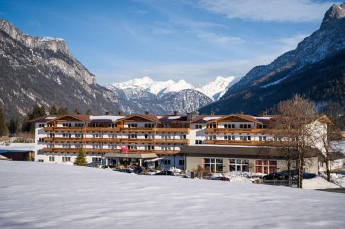 a hotel in the mountains with snow on the ground at KUHOTEL by Rilano in Waidring