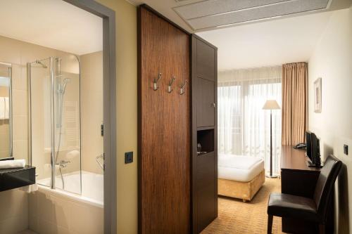 een badkamer met een schuifdeur naar een badkamer met een douche bij The Rilano Hotel Hamburg in Hamburg