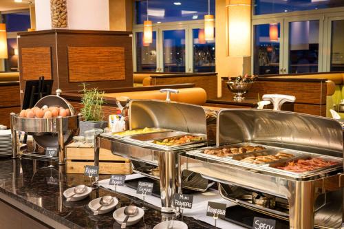 a buffet line with several trays of food at elaya hotel hamburg finkenwerder in Hamburg