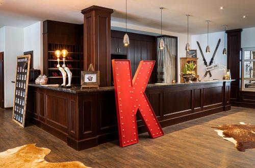 a large red letter k sitting in a room at KUHOTEL by Rilano in Waidring