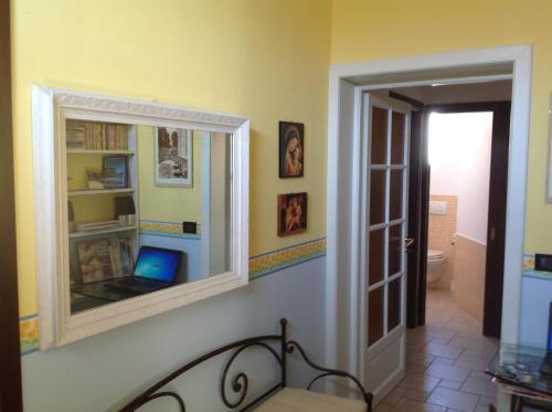 a room with a mirror and a laptop on a wall at B&B Cheap Holidays in Sorso