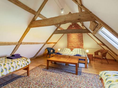 a attic room with two beds and a table at Hemblington Hall Arts And Leisure Ltd in South Walsham