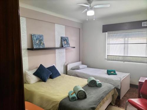 a bedroom with two beds with towels on them at Guest House Patrocinio in Corroios
