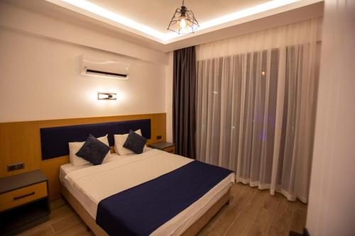a bedroom with a large bed and a window at Eva Apart Kemer in Kemer