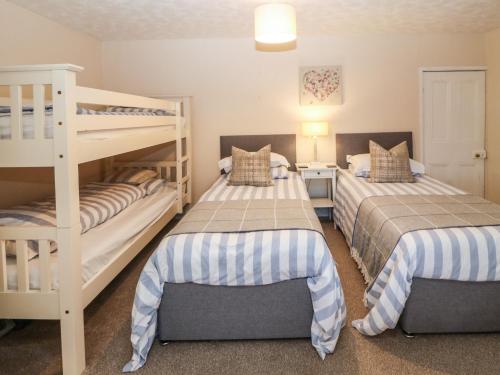 two beds in a room with two bunk beds at Riverside House in Amlwch