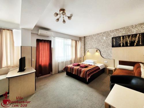 a hotel room with a bed and a television at Vila Dorobantilor in Cluj-Napoca