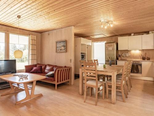 eine Küche und ein Wohnzimmer mit einem Tisch und einem Sofa in der Unterkunft 8 person holiday home in L kken in Løkken