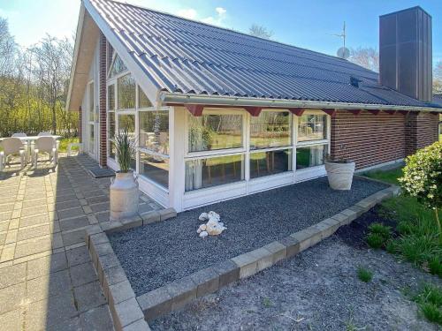 a house with a conservatory with a roof at 4 person holiday home in Hemmet in Hemmet