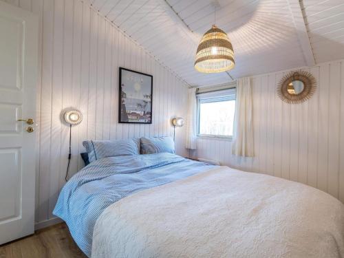 a bedroom with a large bed with a blue blanket at Holiday home Fanø CLXX in Fanø
