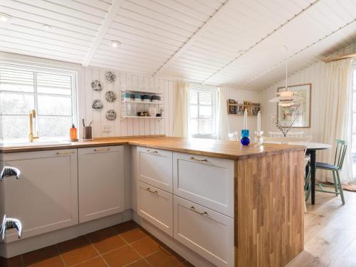 a kitchen with white cabinets and a wooden counter top at Holiday home Fanø CLXX in Fanø
