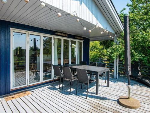 a wooden deck with a table and chairs on it at 7 person holiday home in Ebeltoft in Ebeltoft