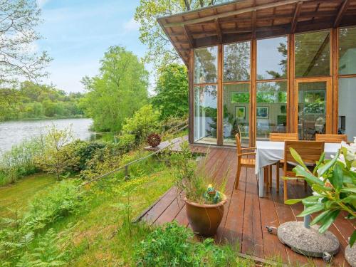 a conservatory with a table and chairs on a wooden deck at 6 person holiday home in Bryrup in Bryrup