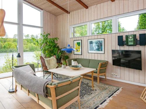 a living room with a table and chairs and a tv at 6 person holiday home in Bryrup in Bryrup