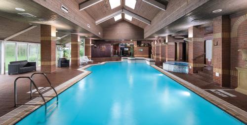duży basen z niebieską wodą w budynku w obiekcie voco St. Johns Solihull, an IHG Hotel w mieście Solihull