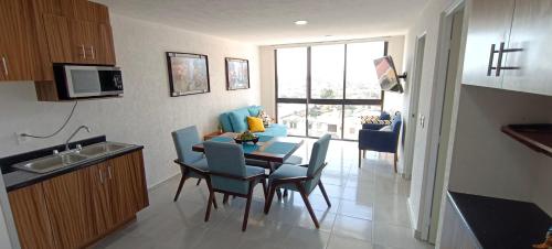 uma cozinha e sala de jantar com mesa e cadeiras em Beautiful and modern apartment em Tonalá